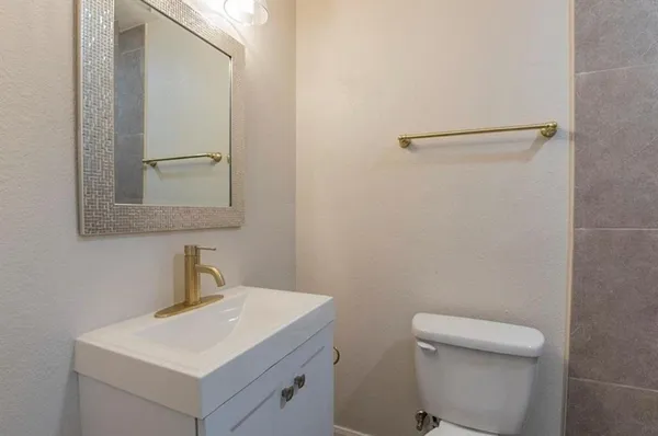 a bathroom with a toilet a sink and vanity