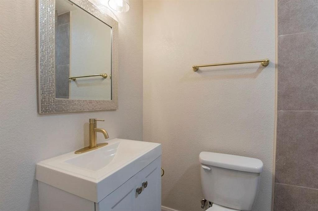 1821 East Grauwyler Road, Unit 188 Irving, TX 75061 - Photo 10 of 20 Bathroom featuring a white vanity with integrated sink, gold-tone faucet, and an illuminated mirror with a mosaic-patterned frame