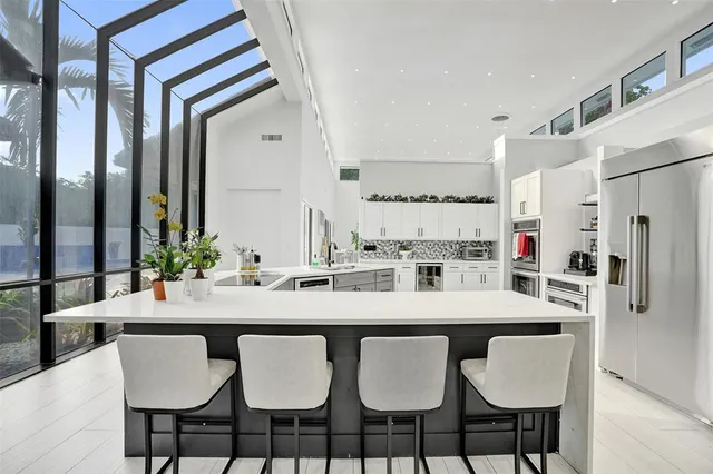 a large white kitchen with a large window