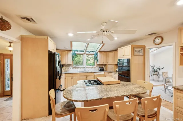 a kitchen with stainless steel appliances granite countertop a sink refrigerator and cabinets