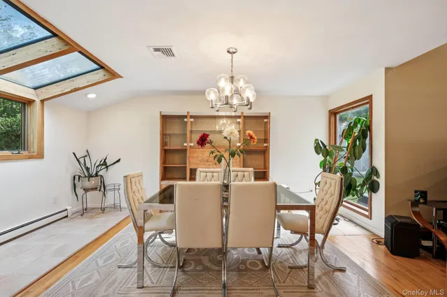 a view of a dining room with furniture a chandelier and wooden floor