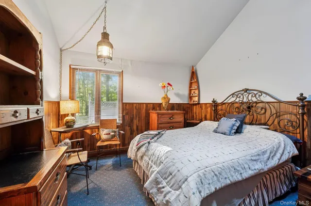 a bedroom with a bed a flat screen tv and dresser