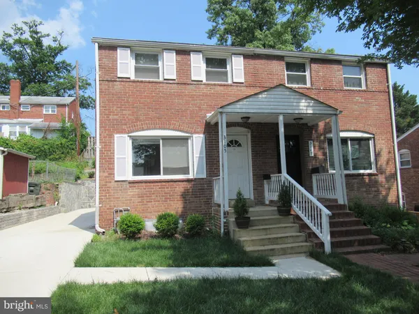 a front view of a house with yard and green space