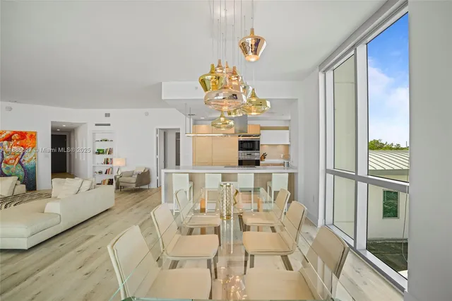a view of a hallway with wooden floor and a living room