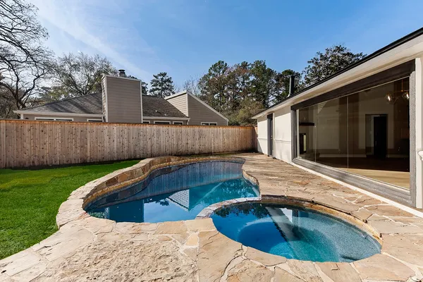 a view of house with backyard and trees in the background