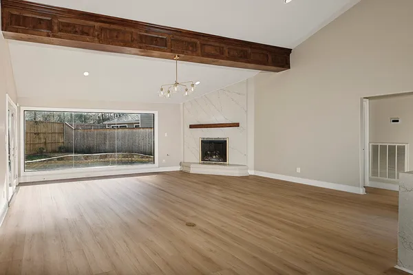 a view of empty room with wooden floor and fireplace