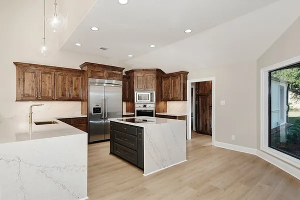 a kitchen with stainless steel appliances granite countertop a sink stove and refrigerator
