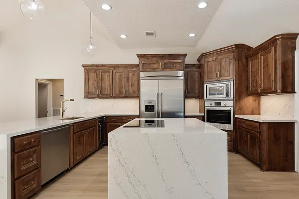 a kitchen with stainless steel appliances a sink stove and refrigerator