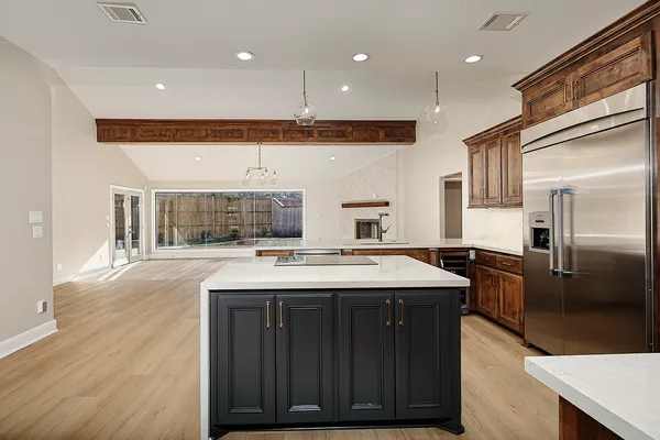 a kitchen with a stove a refrigerator and wooden floor