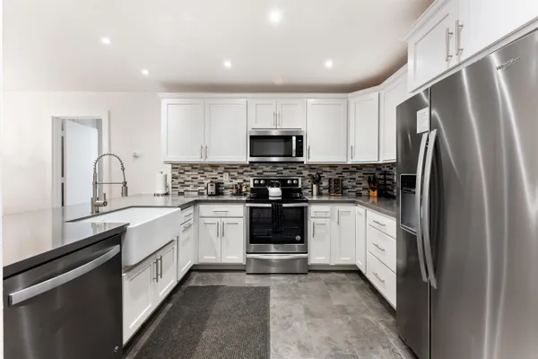 a kitchen with a refrigerator and a stove top oven