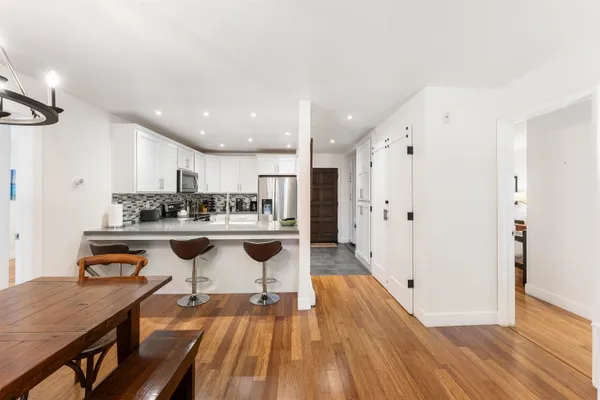 a open kitchen with stainless steel appliances granite countertop a refrigerator and a stove top oven