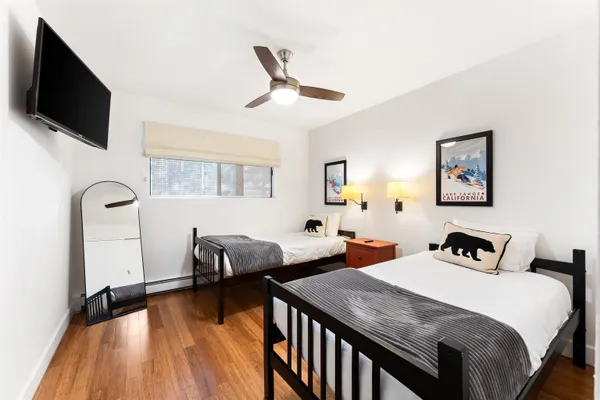 a bedroom with two beds and a flat screen tv