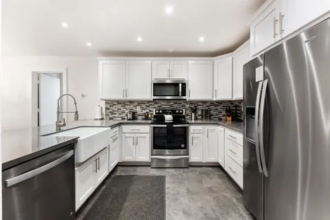a kitchen with a refrigerator and a stove top oven