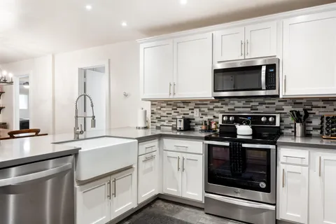a kitchen with white cabinets stainless steel appliances and sink
