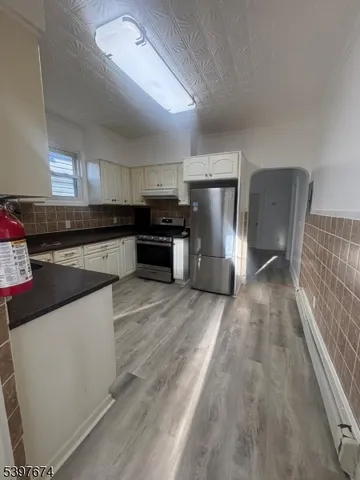 a kitchen with stainless steel appliances granite countertop a refrigerator a stove and a sink with cabinets