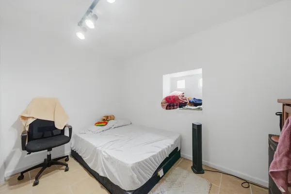 a bedroom with a bed and a chandelier
