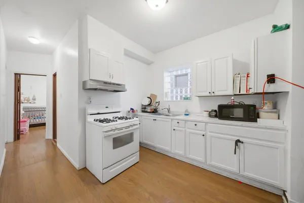 a kitchen with white cabinets and appliances