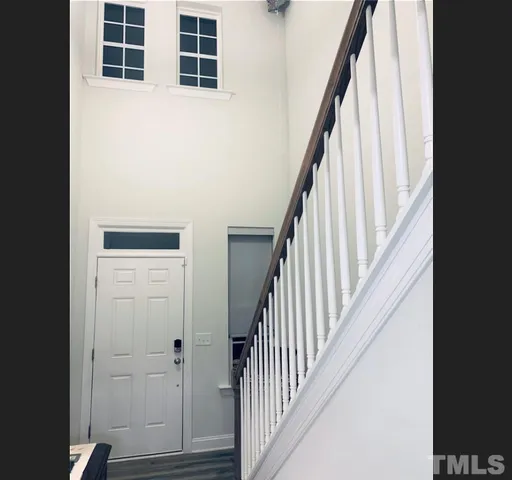 a view of staircase with wooden floor and white walls