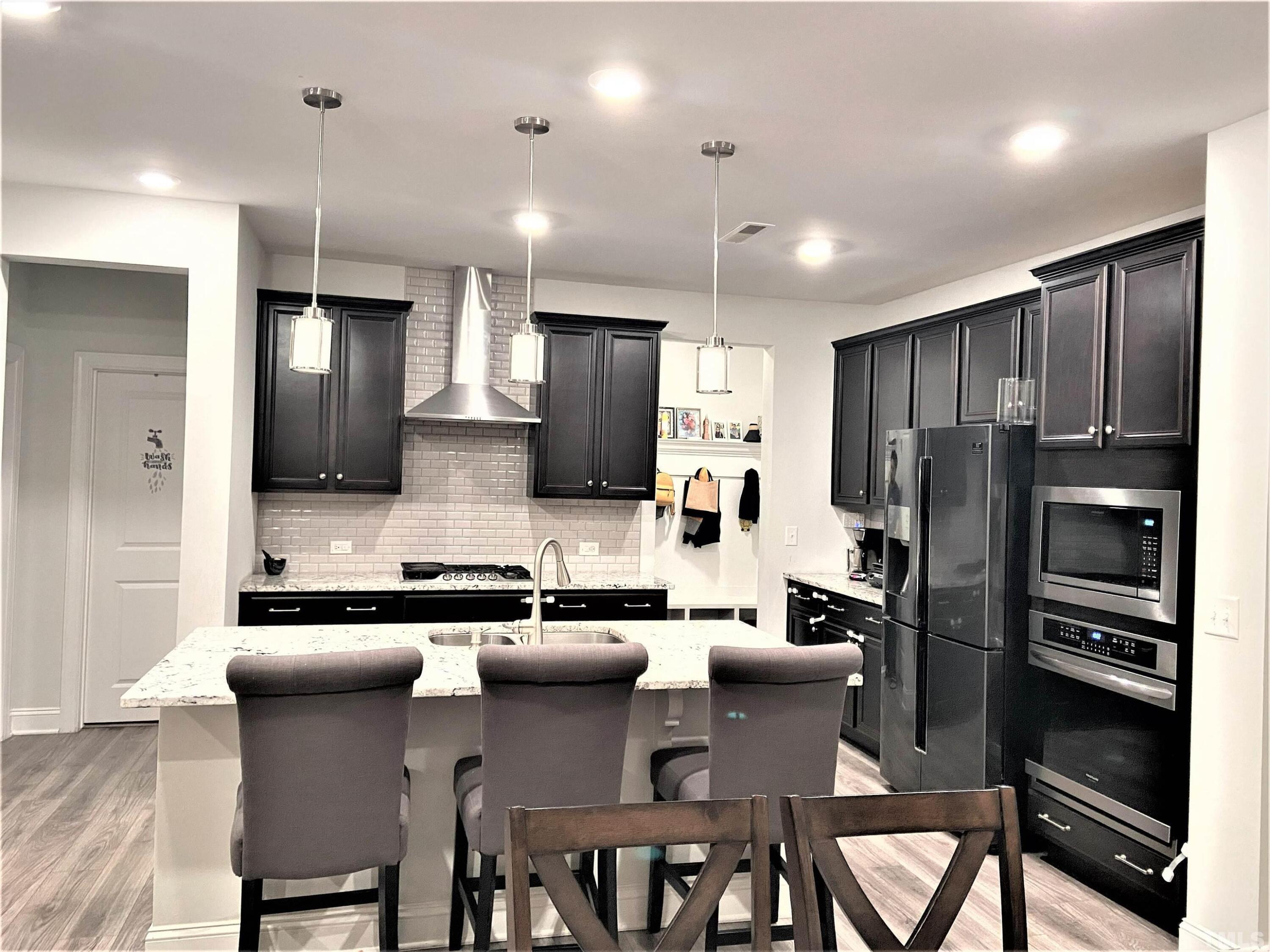 1010 Hero Place Cary, NC 27519 - Photo 8 of 14 a kitchen with stainless steel appliances granite countertop a refrigerator a stove a sink a dining table and chairs