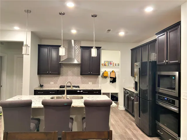 a kitchen with stainless steel appliances granite countertop a sink refrigerator and cabinets