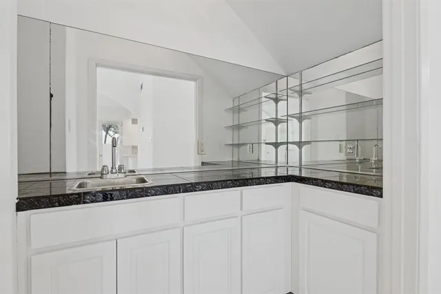 a kitchen with a sink white cabinets and white appliances