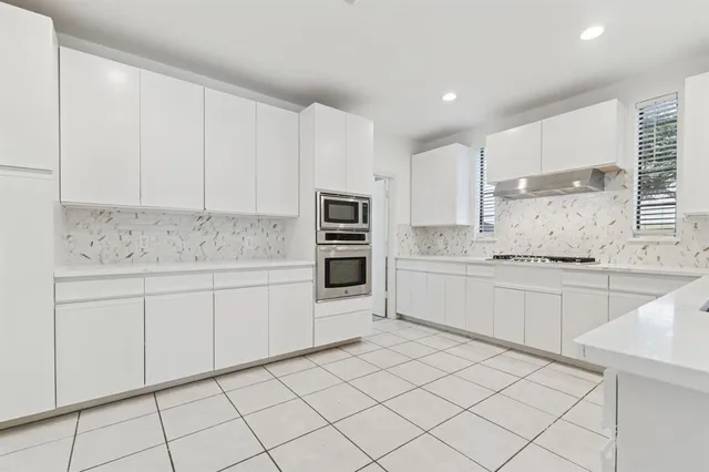 a kitchen with white cabinets appliances and a sink