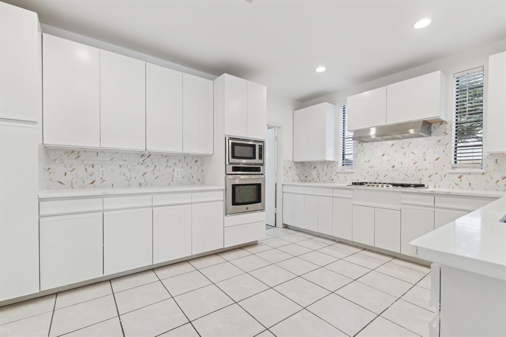 2685 Carnation Drive Richardson, TX 75082 - Photo 17 of 40 a kitchen with granite countertop white cabinets and white stainless steel appliances
