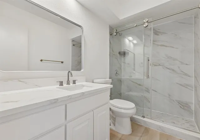 an empty room with chandelier fan and windows