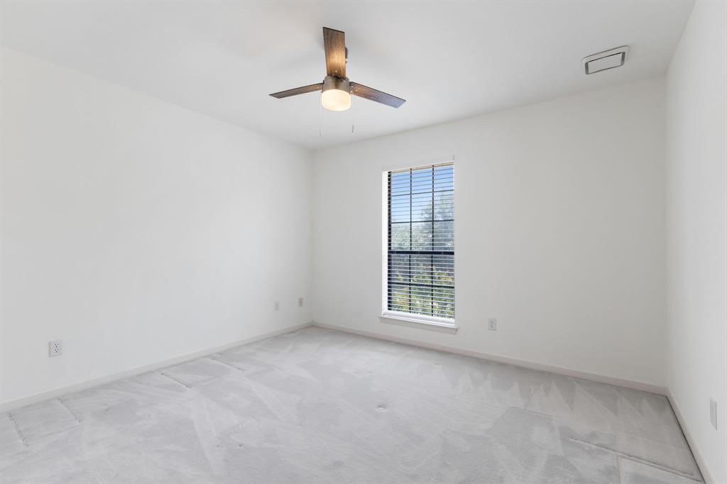 2685 Carnation Drive Richardson, TX 75082 - Photo 32 of 40 an empty room with chandelier fan and windows