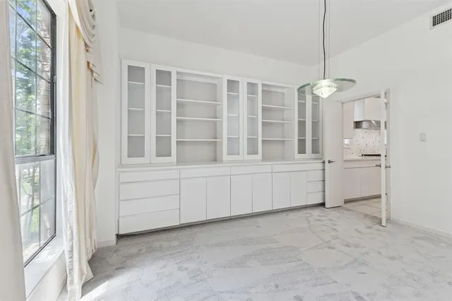 a view of an empty room with wooden floor fireplace and a window