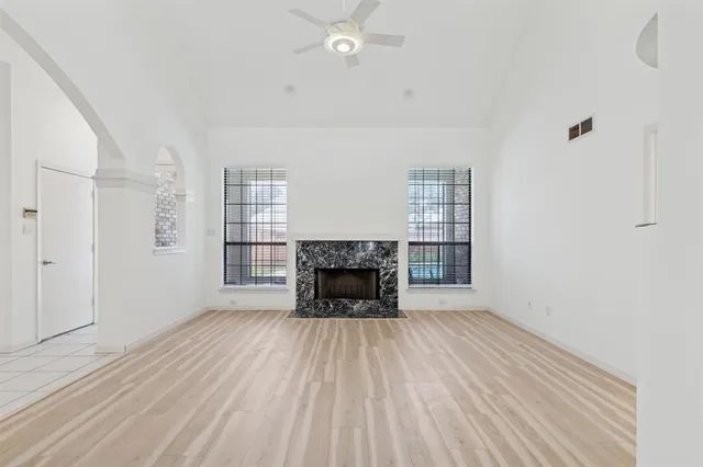 a view of an empty room with a fireplace and a window