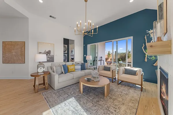 a living room with furniture a chandelier a fireplace and a chandelier