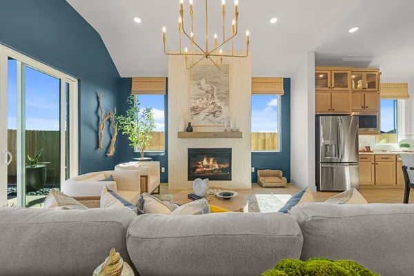 a living room with furniture a fireplace and a chandelier