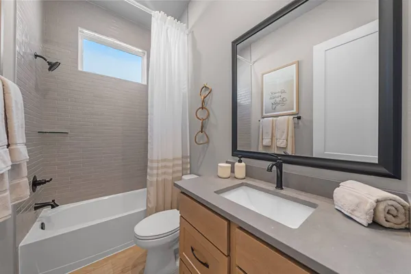 a bathroom with a granite countertop sink toilet a mirror and shower