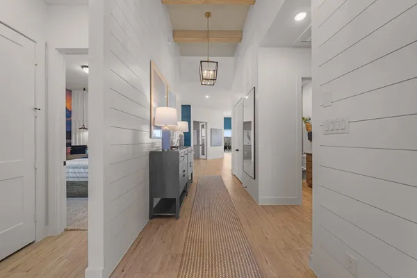 a view of a hallway with wooden floor and staircase