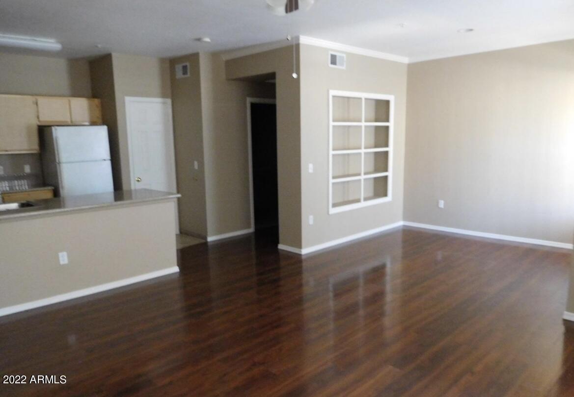 5345 East Van Buren Street, Unit 238 Phoenix, AZ 85008 - Photo 11 of 25 an empty room with wooden floor and windows