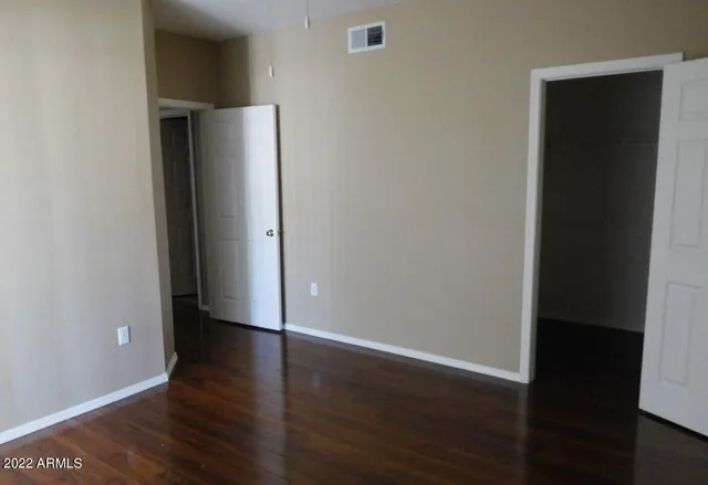 an empty room with wooden floor and closet