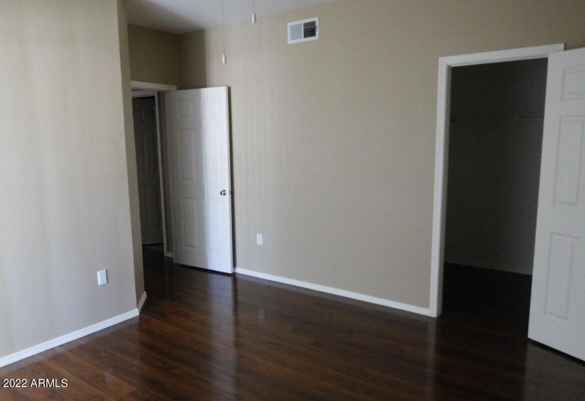 5345 East Van Buren Street, Unit 238 Phoenix, AZ 85008 - Photo 20 of 25 an empty room with wooden floor and closet