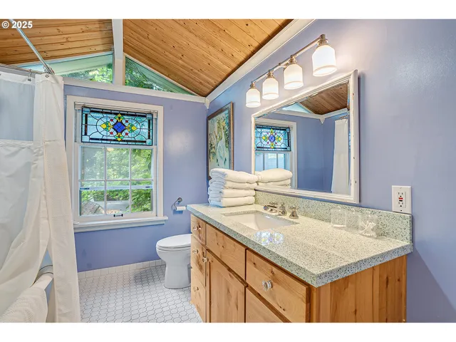 a bathroom with a sink a toilet a mirror and window