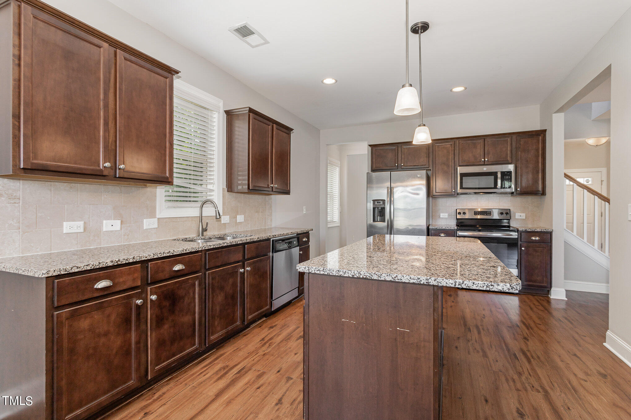 1021 Silver Farm Road Raleigh, NC 27603 - Photo 15 of 42 a large kitchen with granite countertop a large counter top space a sink stainless steel appliances and cabinets