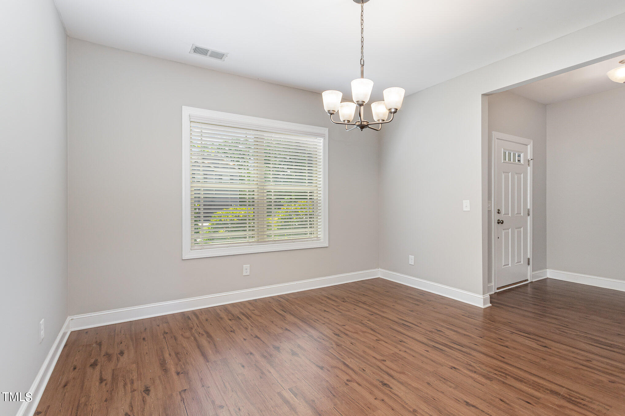 1021 Silver Farm Road Raleigh, NC 27603 - Photo 7 of 42 an empty room with wooden floor and windows