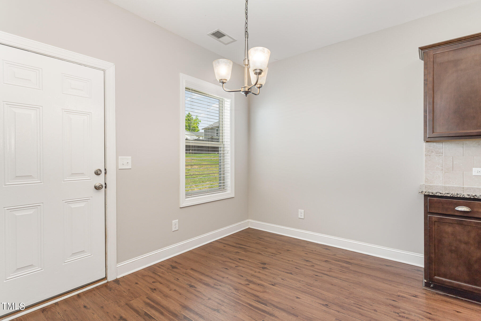 1021 Silver Farm Road Raleigh, NC 27603 - Photo 8 of 42 an empty room with wooden floor cabinet and windows