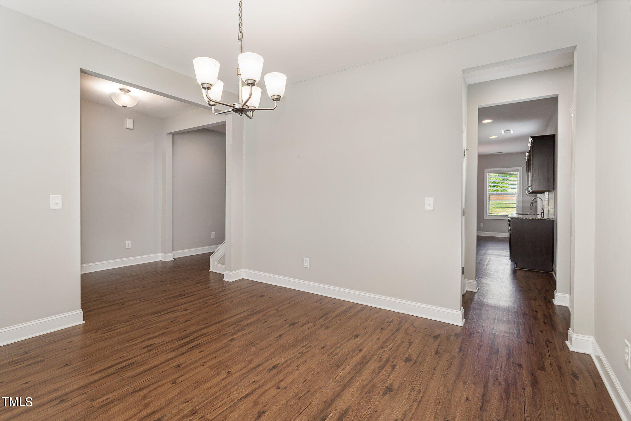 1021 Silver Farm Road Raleigh, NC 27603 - Photo 9 of 42 a view of a hallway with wooden floor and a chandelier