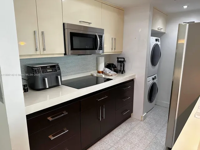 a kitchen with stainless steel appliances granite countertop a sink a stove a microwave a refrigerator and cabinets