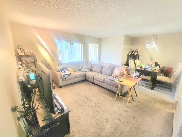 a living room with furniture a window and a flat screen tv