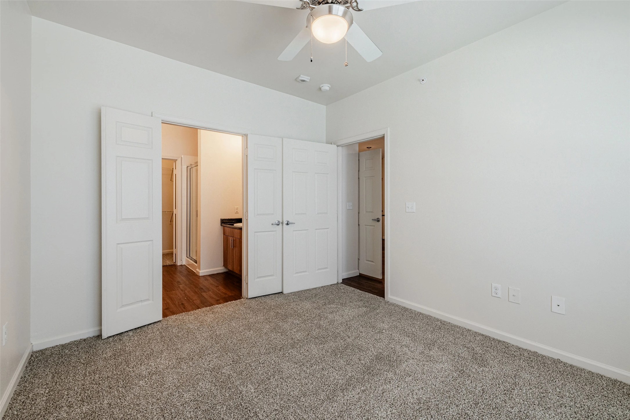 5605 Springdale Road, Unit 444411 Austin, TX 78723 - Photo 5 of 27 Up to 8 weeks free rent and waiving the standard deposit with approved credit and landlord verification.edroom featuring dark colored carpet, connected bathroom, and a ceiling fan
