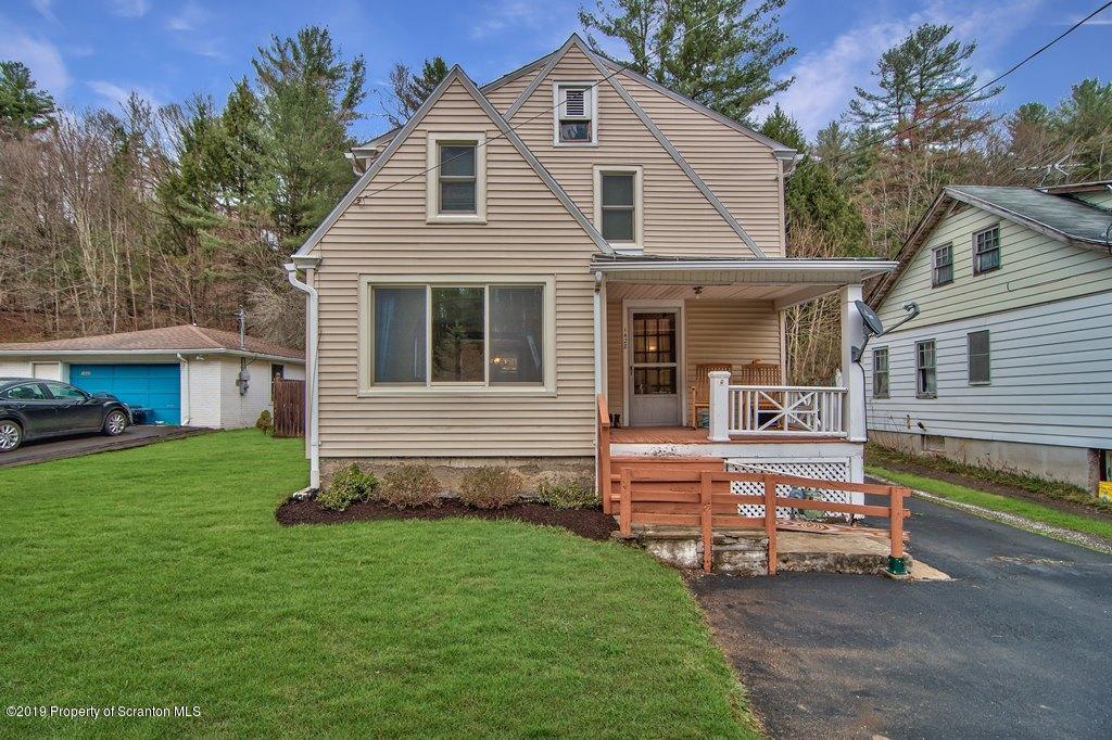 a view of a house with a yard and sitting area