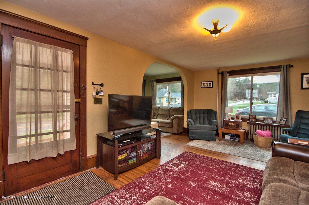 1428 Hillside Road Shavertown, PA 18708 - Photo 6 of 19 a living room with furniture a flat screen tv and a floor to ceiling window