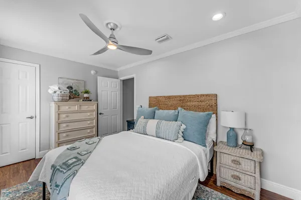 a bedroom with a bed a dresser next to a window