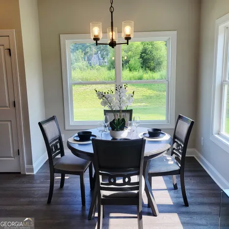 a view of a dining room with furniture a chandelier and wooden floor
